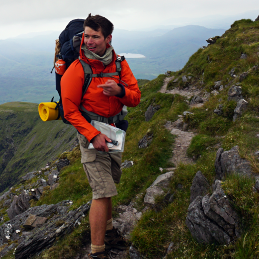 A photograph of Harry Kuril hiking on a mountain path on Carrauntoohil in Ireland.